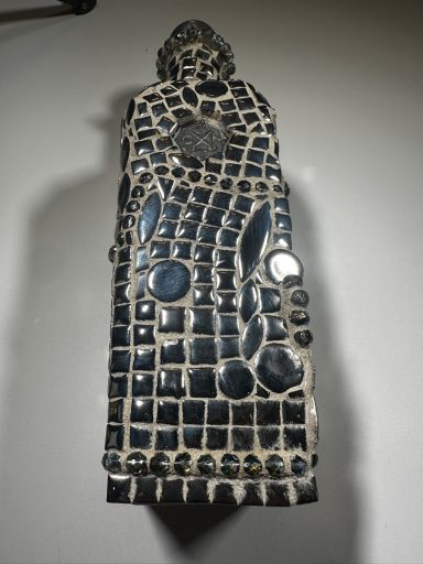 Tequila bottle is now a reusable decanter with a mosaic pattern, featuring various circular and oval shapes.