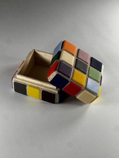 Colorful, open box designed like a Rubik's Cube, showcasing various colored squares.